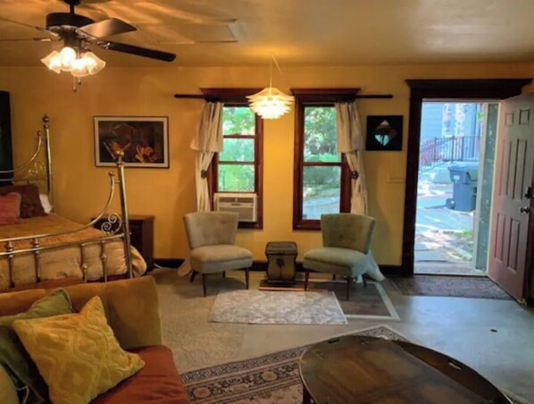 Cozy living room with a fireplace, sofa, and armchairs, offering a warm and inviting atmosphere.
