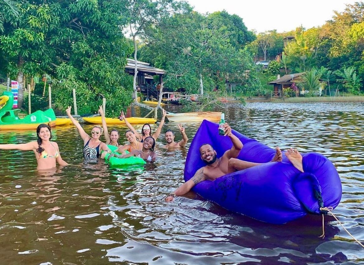 A group of people floating on a lake with inflatable rafts.