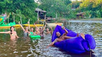A group of people floating on a lake with inflatable rafts.