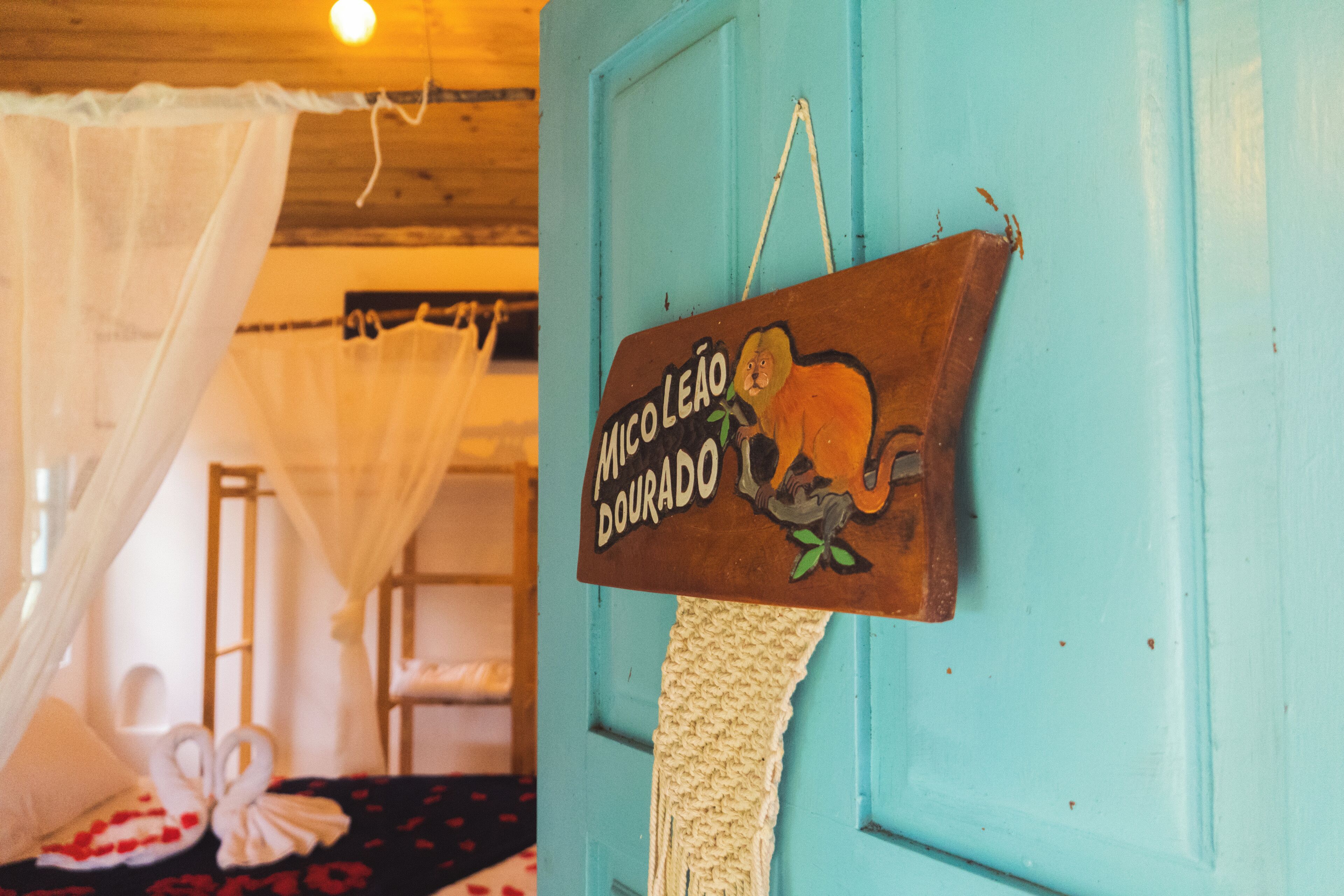 A room with a bed, a hanging sign, and a blue door.