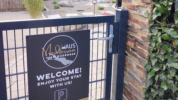 A gated entrance with a welcome sign for a hotel named "Mediteran."