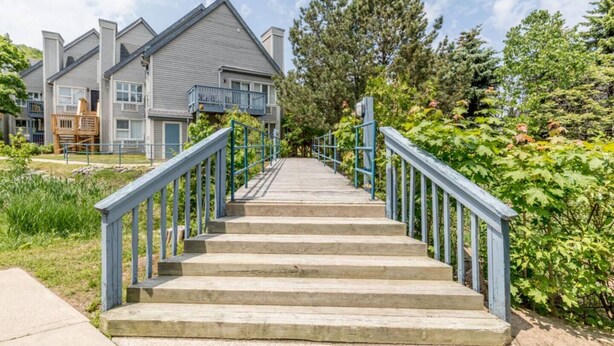 Una escalera que lleva a un edificio residencial con techo gris y barandillas azules.