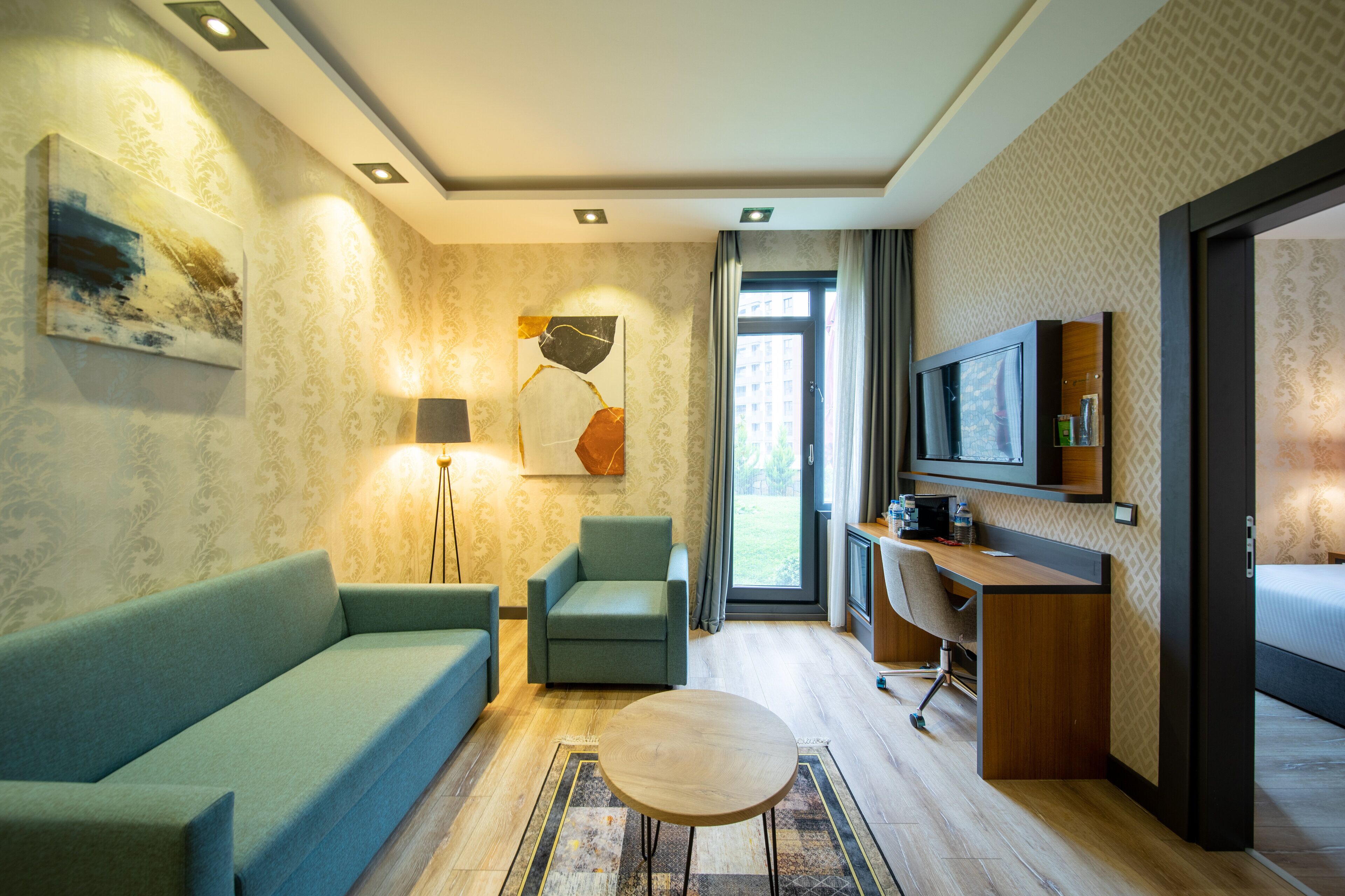 Un salon moderne comprenant un canapé, un fauteuil, une table basse et un téléviseur.