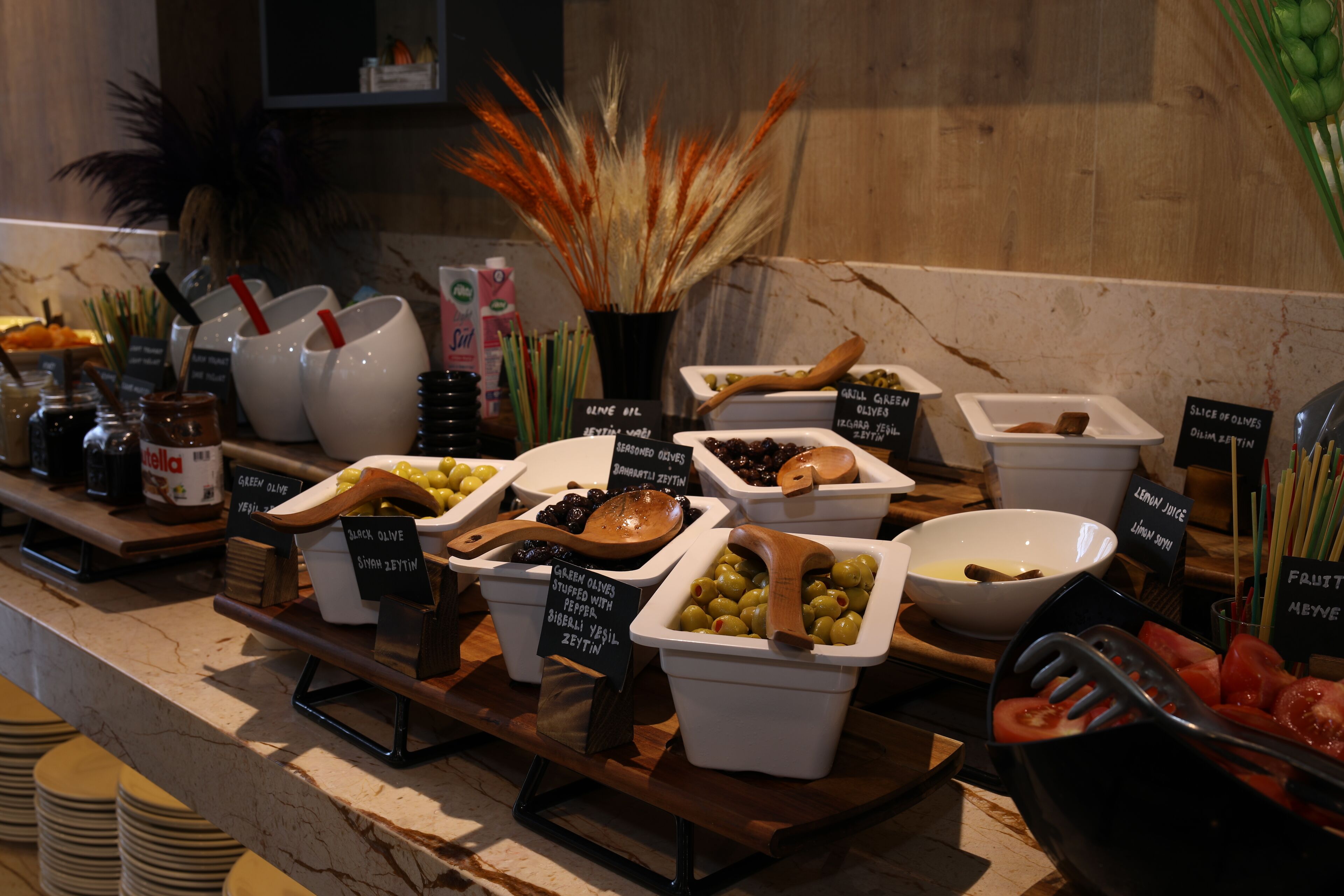 Un buffet proposant différents plats, notamment des olives, des olives vertes et des olives farcies.
