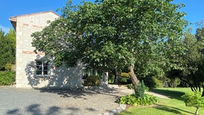 A stone building with a paved driveway and a well-maintained lawn.