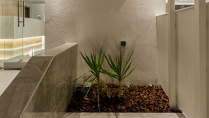 A reception area with a sign for 'Anassa Suites' and a small planter with plants. - Anassa Suites (Dio-Olympos)