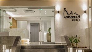 A modern hotel entrance with a marble staircase, a reception desk, and a sign for 'Anassa Suites'. - Anassa Suites (Dio-Olympos)