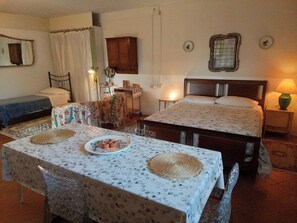 Une chambre avec deux lits, une table sur laquelle se trouve une assiette de nourriture, un miroir et une lampe.