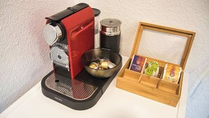 Una cafetera, un recipiente metálico y una caja de madera con productos envasados.
