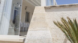 A modern building with a glass facade, a stone base, and a clear blue sky in the background. - Apulian Villa (Conversano)