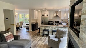 A modern kitchen with a central island, stainless steel appliances, and pendant lighting.