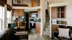 A spacious loft-style living area with a kitchen, a dining area, and a staircase leading to an upper level. - Beachfront House- The Sea Eagle (Sekiu)