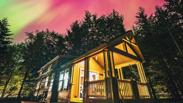 A cabin with a porch, wooden steps, and a view of the aurora borealis. - Beachfront House- The Sea Eagle (Sekiu)