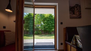 En modern inredning med en skjutdörr i glas som leder ut till en trädgård.