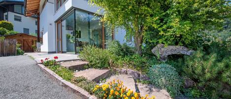 Ein modernes Haus mit einem gepflegten Garten, einschließlich verschiedener Pflanzen und Blumen.