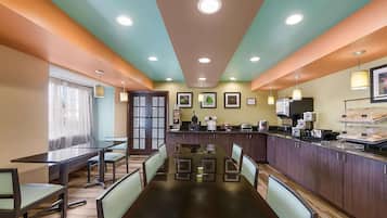 A restaurant with a long communal table, individual booths, and a counter with food and drinks.
