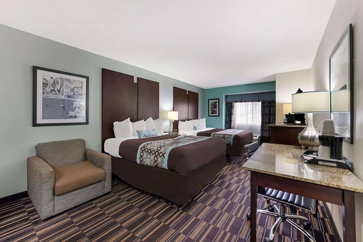 Ein Hotelzimmer mit einem großen Bett, einem Schreibtisch, einem Sessel und einer kleinen Couch.