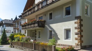 A two-story building with balconies, flower boxes, and a sign reading "JALVE APARTMENTS".