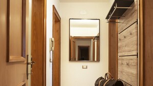 Ein Flur mit Holztüren, einer Bank und einem Spiegel an der Wand.
