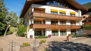 Een hotel met meerdere verdiepingen, balkons, een stenen gevel en een heldere lucht.