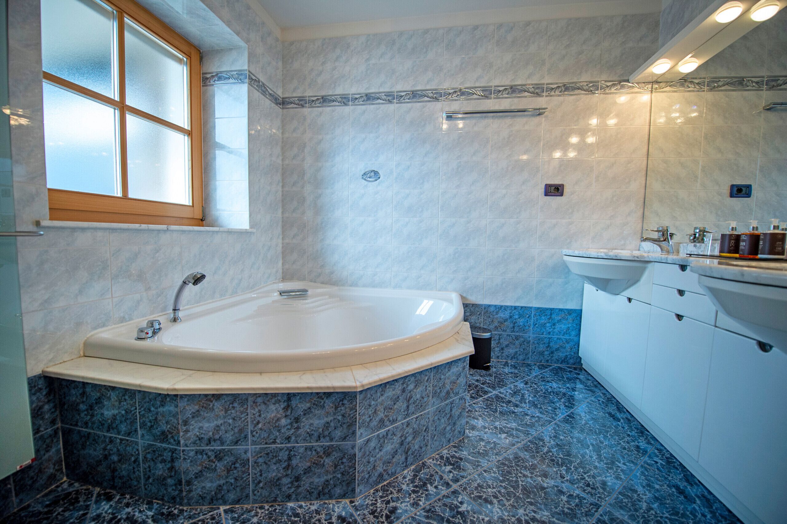 A modern bathroom with a freestanding bathtub, a large mirror, and a vanity with a sink.