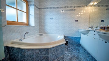 A modern bathroom with a freestanding bathtub, a large mirror, and a vanity with a sink.