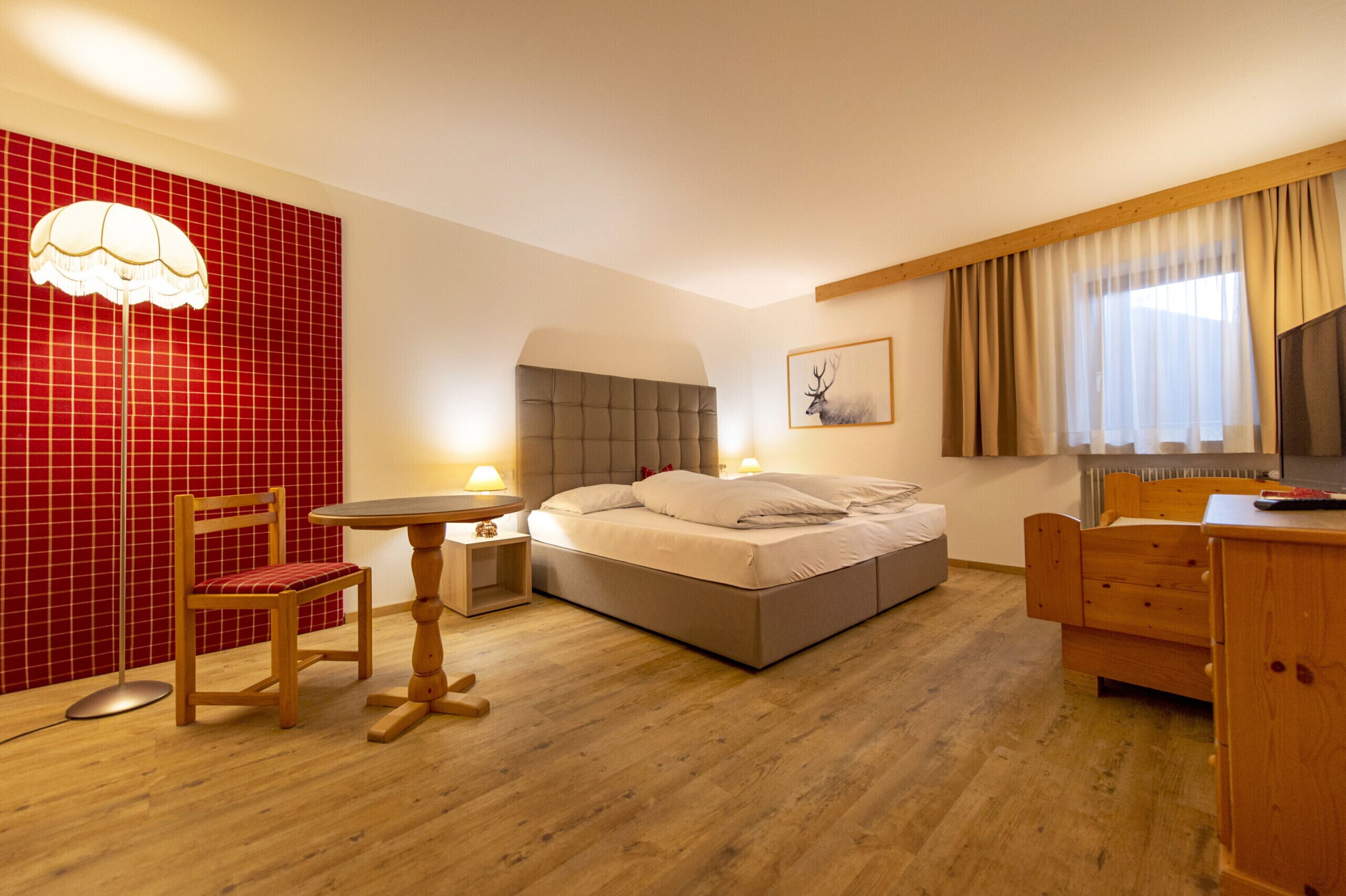Habitació d'hotel amb un llit, una cadira, una taula i un escriptori.