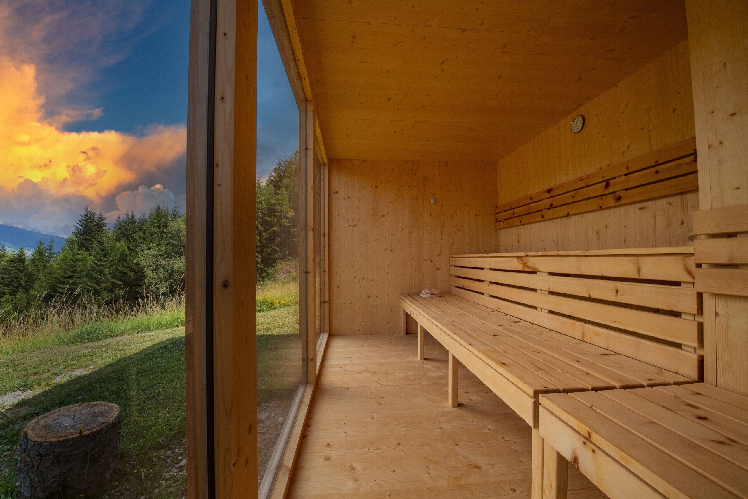 Uma sauna de madeira com bancos e uma janela grande.