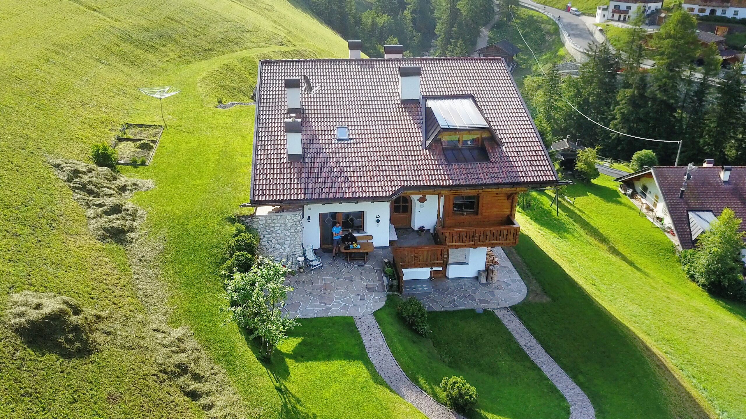 A house with a tiled roof, a stone foundation, and a small porch.