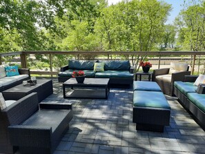 An outdoor patio with wicker furniture, a green sofa, and a coffee table. - Charming Cottage in Stockholm, WI
Nations Best: Pies, Scenic Drive, Small Town! (Stockholm)