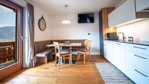 Une cuisine moderne avec un coin repas, un plancher en bois et une grande fenêtre offrant une belle vue.