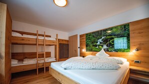 Une chambre avec un lit superposé en bois et une grande fresque murale représentant une cascade.
