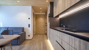 Een moderne keuken met houten kastjes, een zwart aanrecht en een inbouwoven.