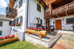 A traditional building with wooden balconies, stone steps, and flower planters. - 167A Apartments Bern (Ortisei)