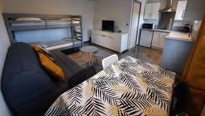 A compact hotel room with a bunk bed, a sofa, a small dining table, and a kitchenette. - Country cottage (Flassans-sur-Issole)