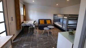A compact room with a sofa, bunk beds, a dining table, and a small round table. - Country cottage (Flassans-sur-Issole)