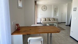 Une cuisine moderne avec un plan de travail en bois, des chaises blanches et une table à manger.