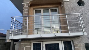 Un bâtiment à deux étages doté d’un balcon, d’une fenêtre et d’une porte.