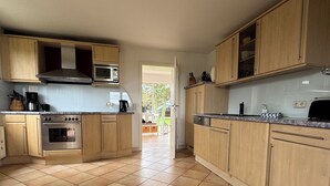 A spacious kitchen with wooden cabinets, a built-in oven, and a microwave.