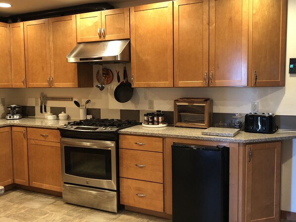 A kitchen with wooden cabinets, stainless steel appliances, and a toaster.