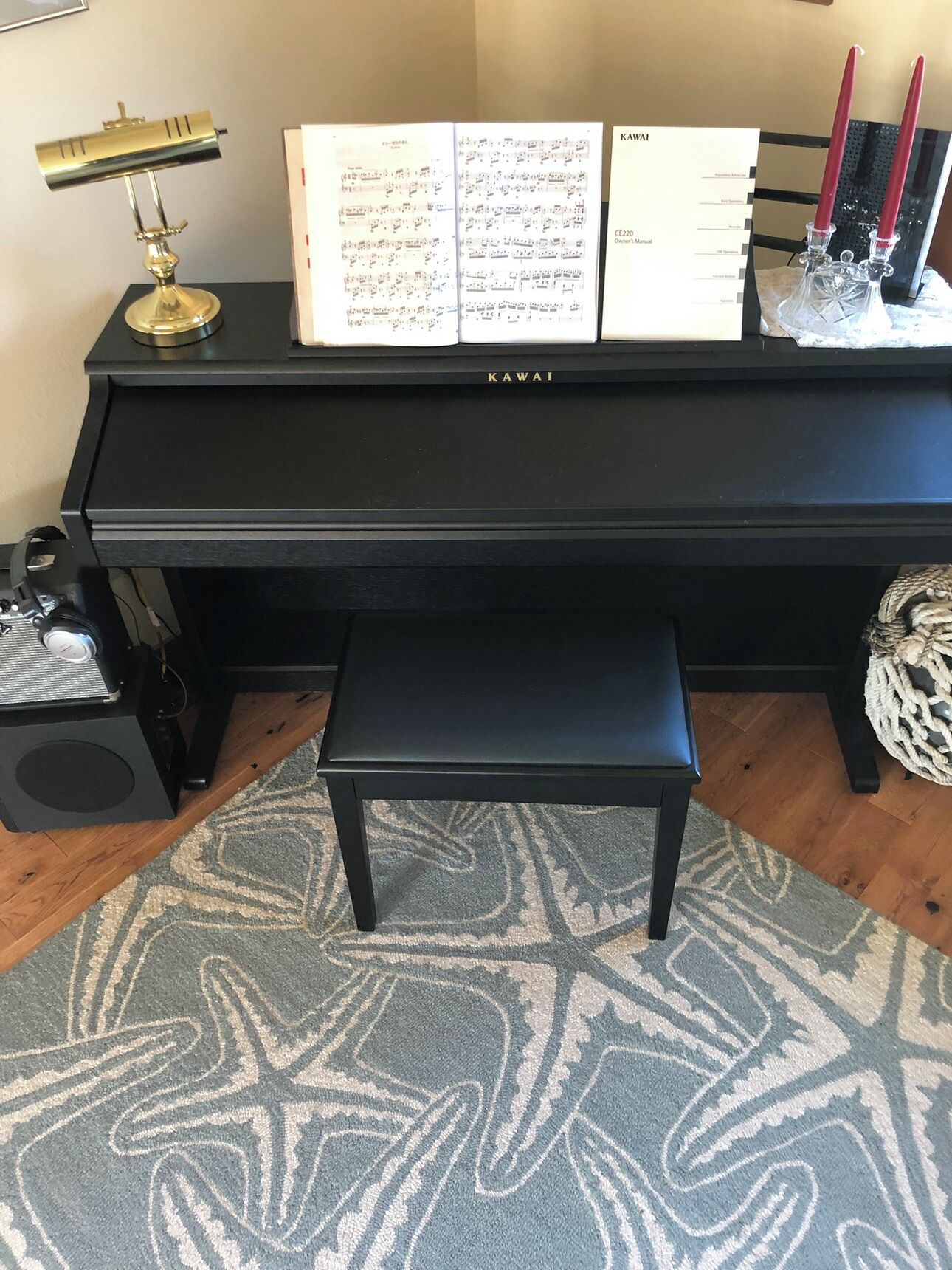 A black piano with sheet music, a music stand, and a bench in front.