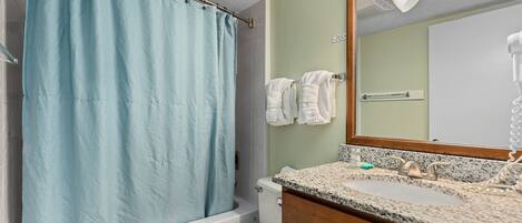 Ein Badezimmer mit Badewanne, Toilette, Waschbecken und Spiegel.