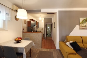 Relax in a stylish living space with a dining area, sofa, and fully equipped kitchen.
