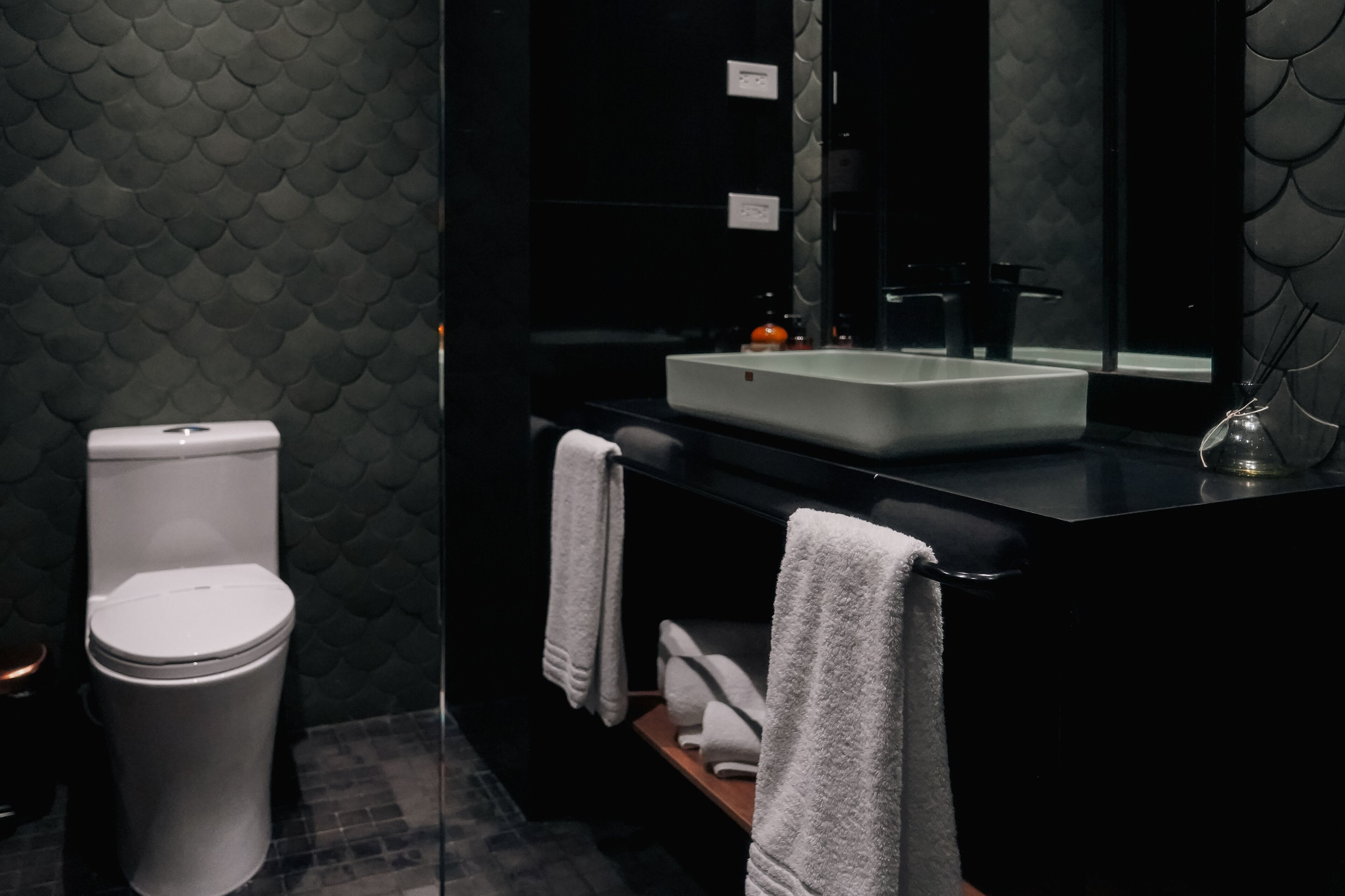 Un baño moderno con inodoro, lavabo y espejo.