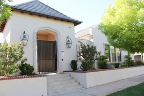 Traditional architecture with a symmetrical facade, featuring a dark gate and lantern-style lights.