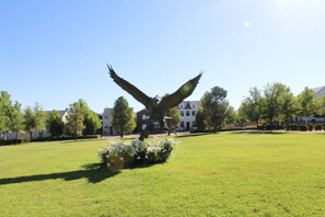 Stunning lawn area with a majestic eagle sculpture, surrounded by residential and institutional buildings.