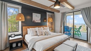 Ein Schlafzimmer mit einem großen Bett, einem Deckenventilator und Blick ins Freie.