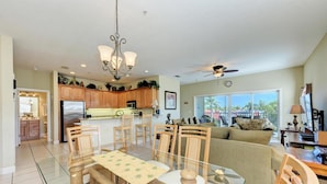 A spacious living area with a dining table, chairs, a sofa, and a kitchen in the background. - Bradenton Beach Club Bliss-2 Bedroom-2 Bathroom Condo-2 Pools-hottub-private Beach Access (Bradenton Beach)