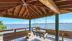 A wooden deck with a covered area, benches, and a swing. - Bradenton Beach Club Bliss-2 Bedroom-2 Bathroom Condo-2 Pools-hottub-private Beach Access (Bradenton Beach)