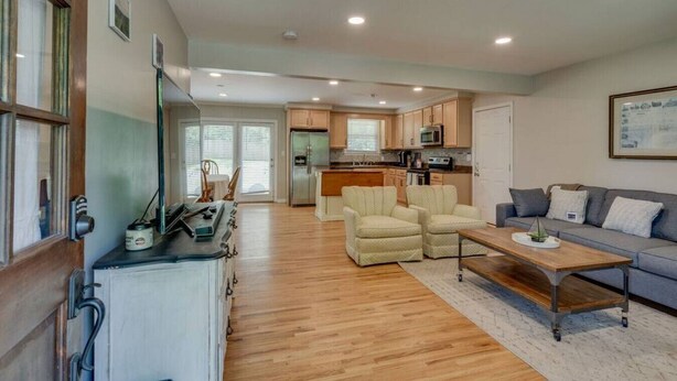 A spacious living area with a sofa, armchairs, and a coffee table. A kitchen with modern appliances is visible in the background. - Casa Rover - Pet Friendly w/ Fenced-in Yard, Family Friendly, Mins to Downtown Nashville (Nashville)